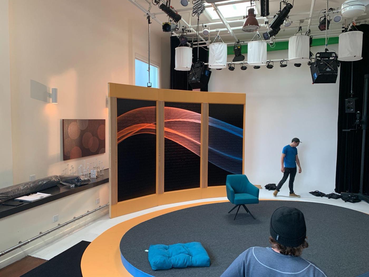The curved three-panel screen wall standing on the finished oval deck, displaying the Edge World orange-and-blue particle-and-code artwork