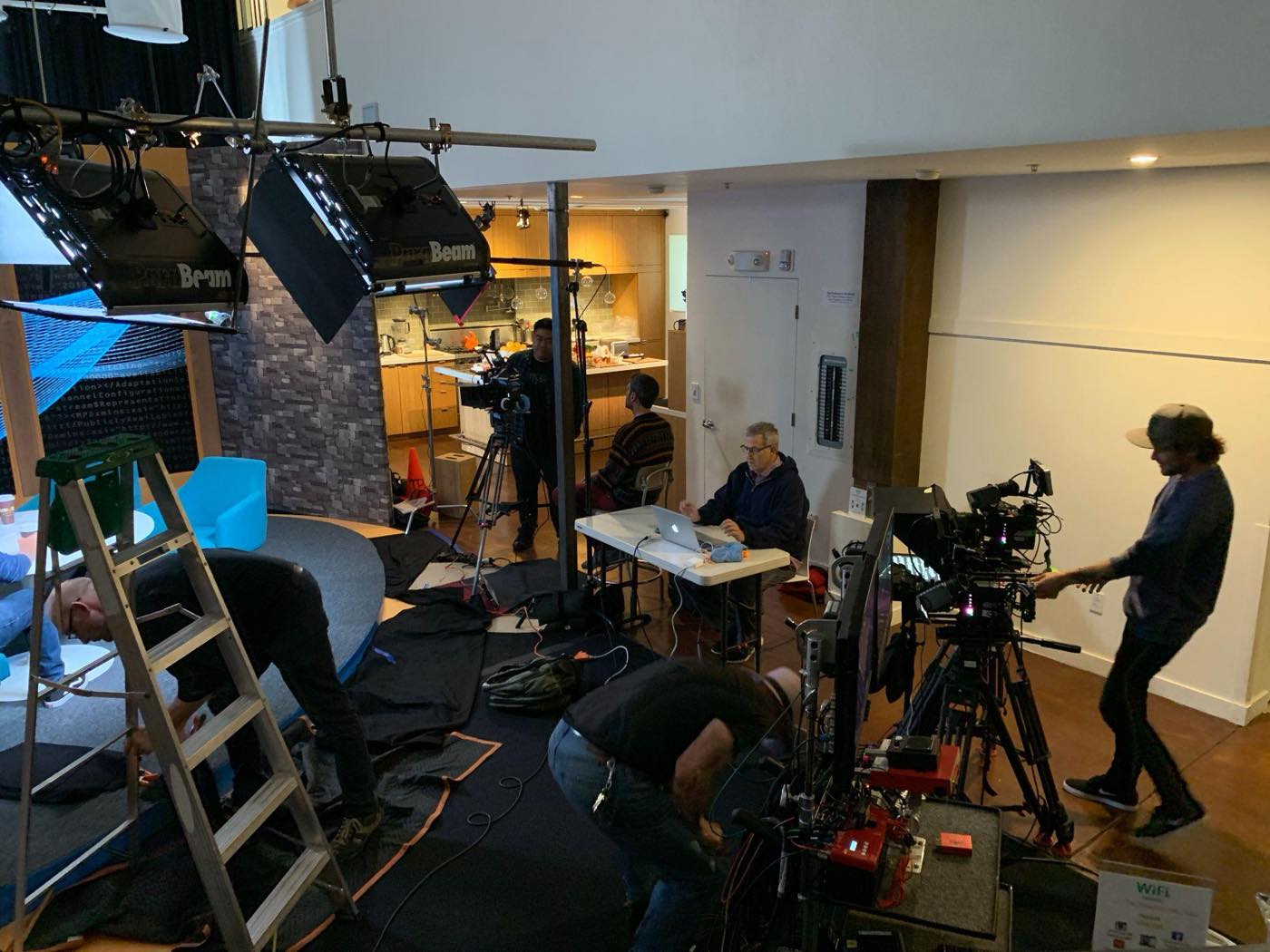 The camera village beside the set — operators, a laptop monitor station, and the ParaBeam rig overhead